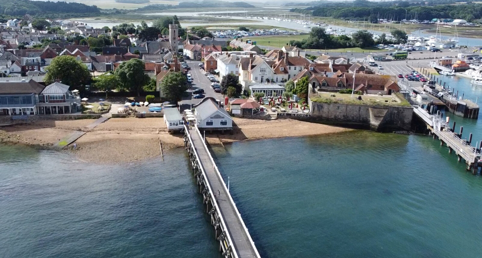 Aerial view of Yarmouth harbour on the Isle of Wight with sailing boats moored beside the historic castle and pier